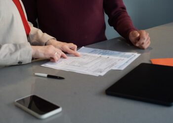 Two professionals reviewing paperwork at a conference table during a business meeting in San Francisco.