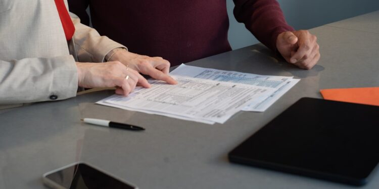 Two professionals reviewing paperwork at a conference table during a business meeting in San Francisco.