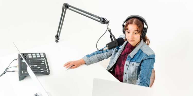 Woman recording podcast looking surprised with microphone