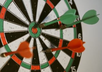 Success hitting target aim goal achievement concept background - three darts in bull's eye close up. red three darts arrows in the target center business goal concept
