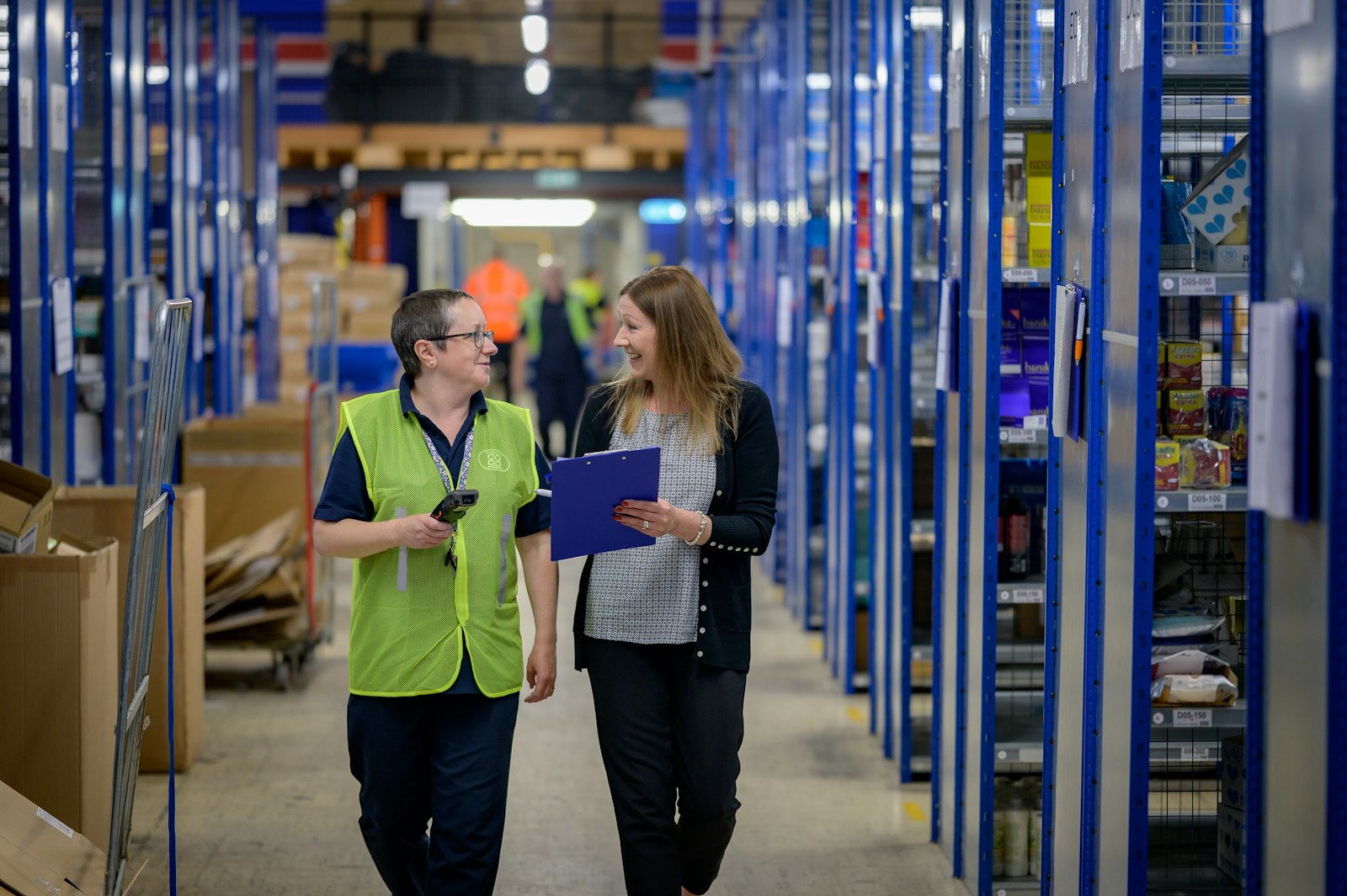 Medewerkers in hesjes aan het werk in een magazijn