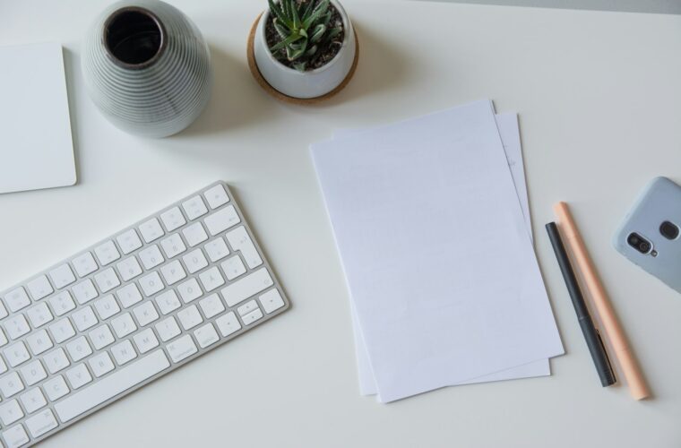 Ondernemer scant bonnetjes en facturen aan een bureau met ordners