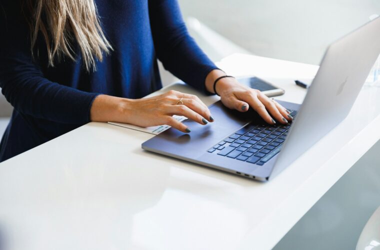 Medewerker van een klein bedrijf werkt met een AI-assistent op een laptop