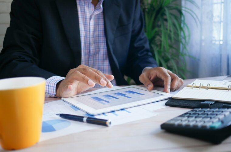 Ondernemer bekijkt financiele cijfers van zijn bv aan een bureau