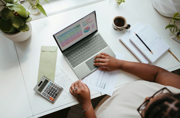 Jonge ondernemer werkt aan zijn administratie op een laptop
