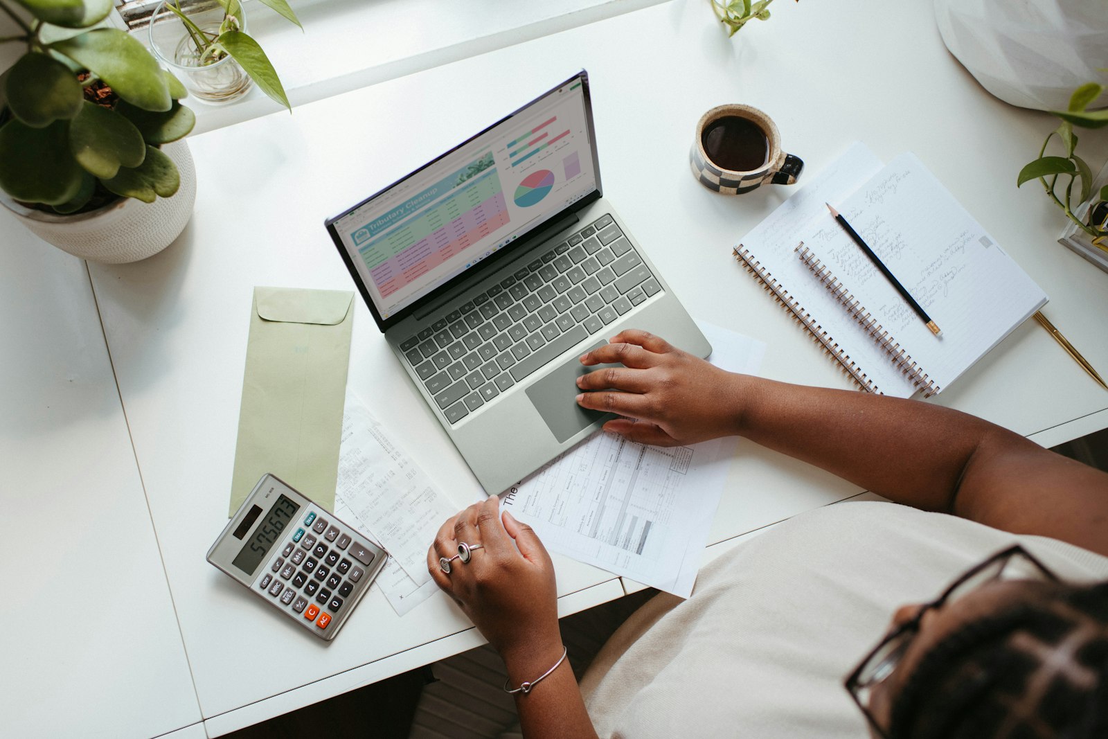 Jonge ondernemer werkt aan zijn administratie op een laptop