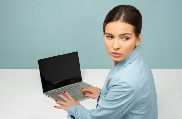 Medewerker controleert beveiligingsmeldingen op een laptop op kantoor