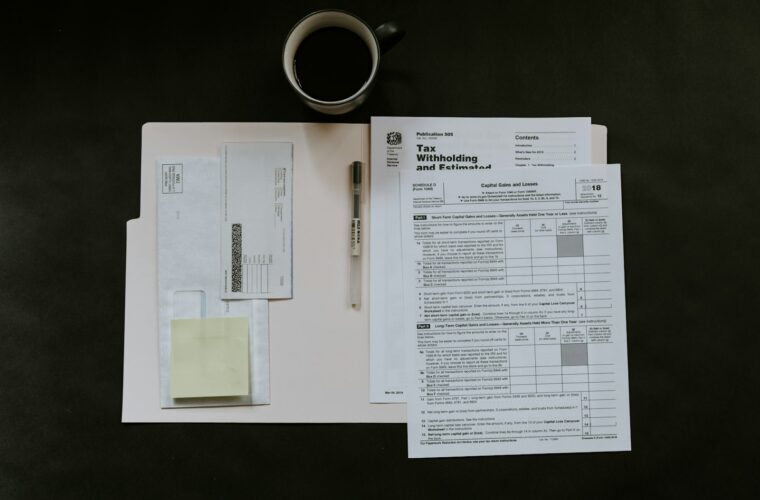 Ondernemer bekijkt een stapel onbetaalde facturen aan een bureau