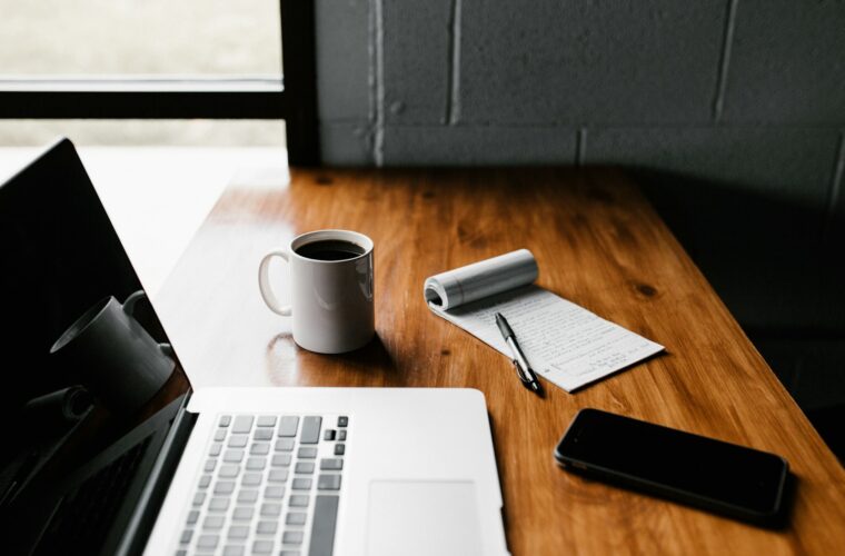 Ondernemer achter een bureau vol papieren en een laptop met administratie