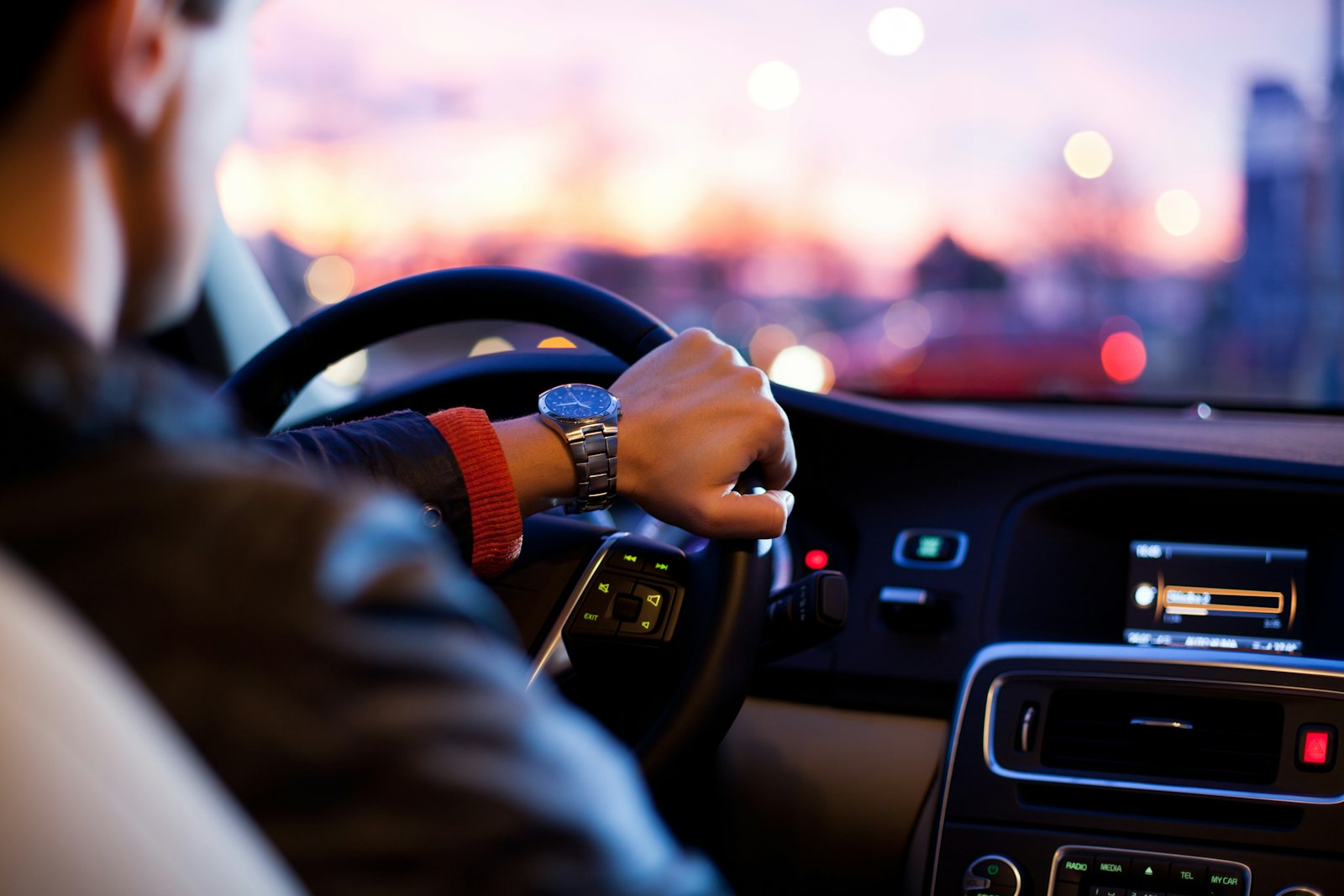Hand aan het stuur van een auto tijdens een rit over de weg