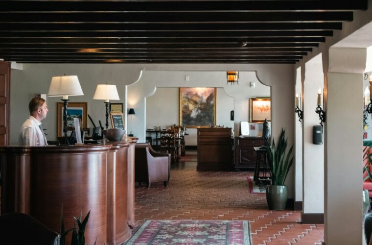 Receptie van een klein hotel met een gast die incheckt