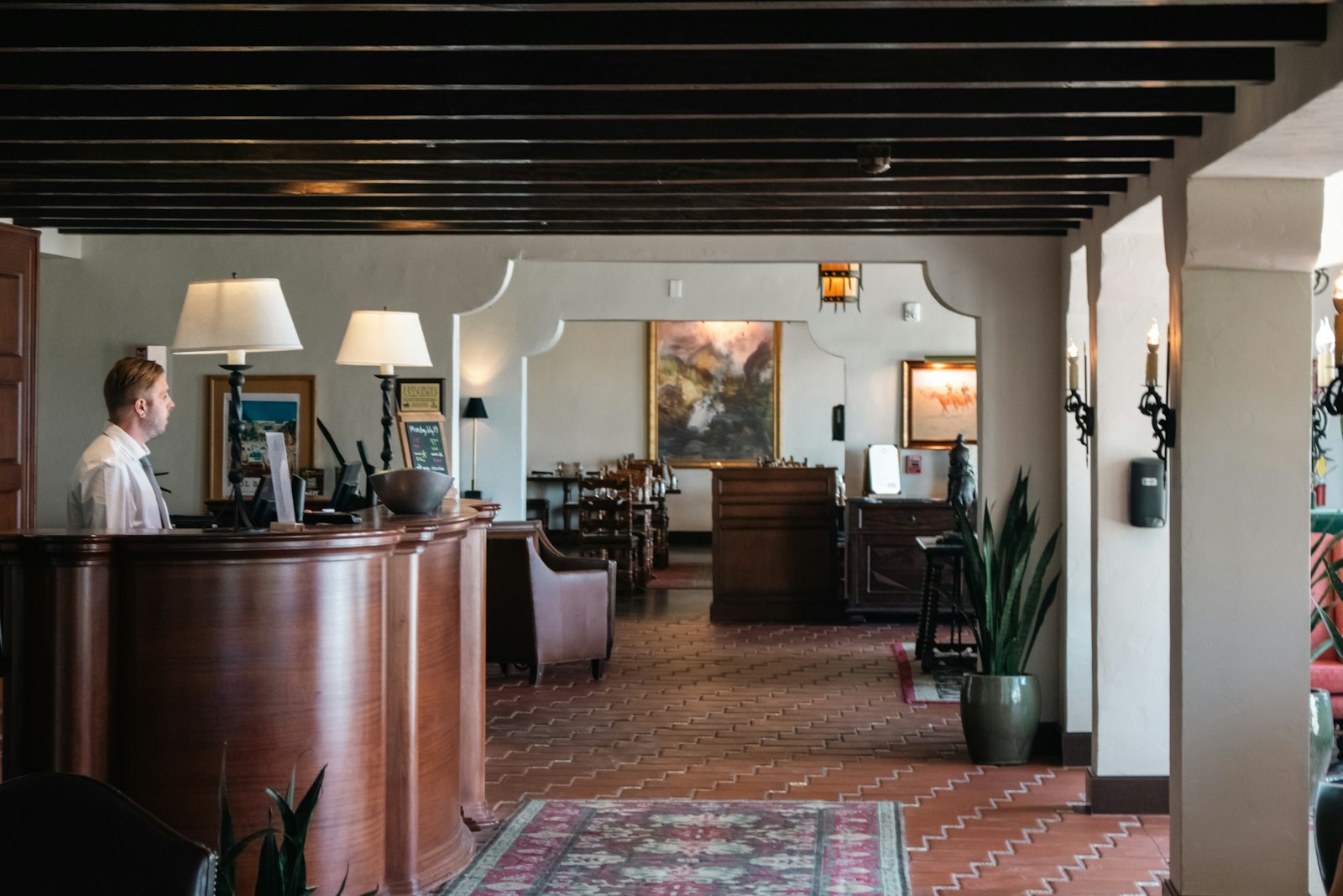 Receptie van een klein hotel met een gast die incheckt