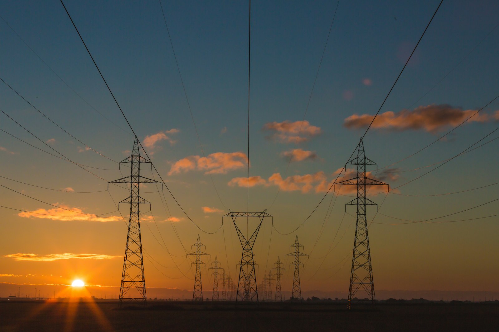 Hoogspanningsmasten en een transformatorstation bij een bedrijventerrein