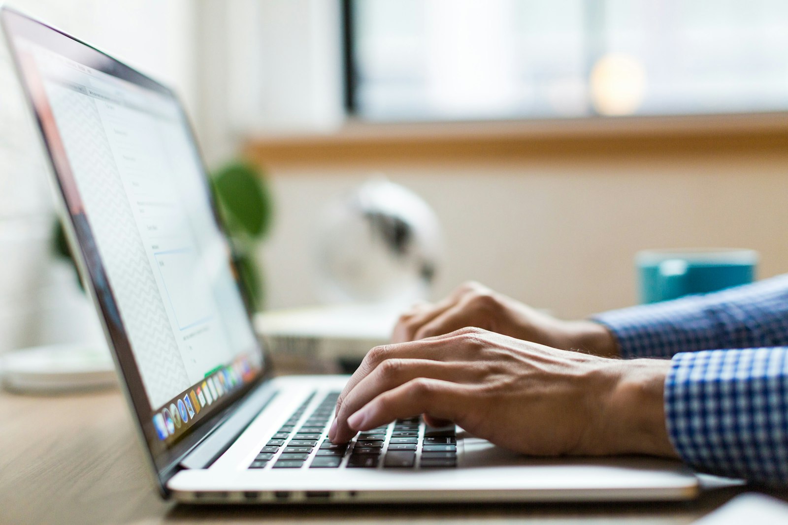 Zzp'er bekijkt zijn zakelijke bankrekening op een laptop met een betaalpas in de hand
