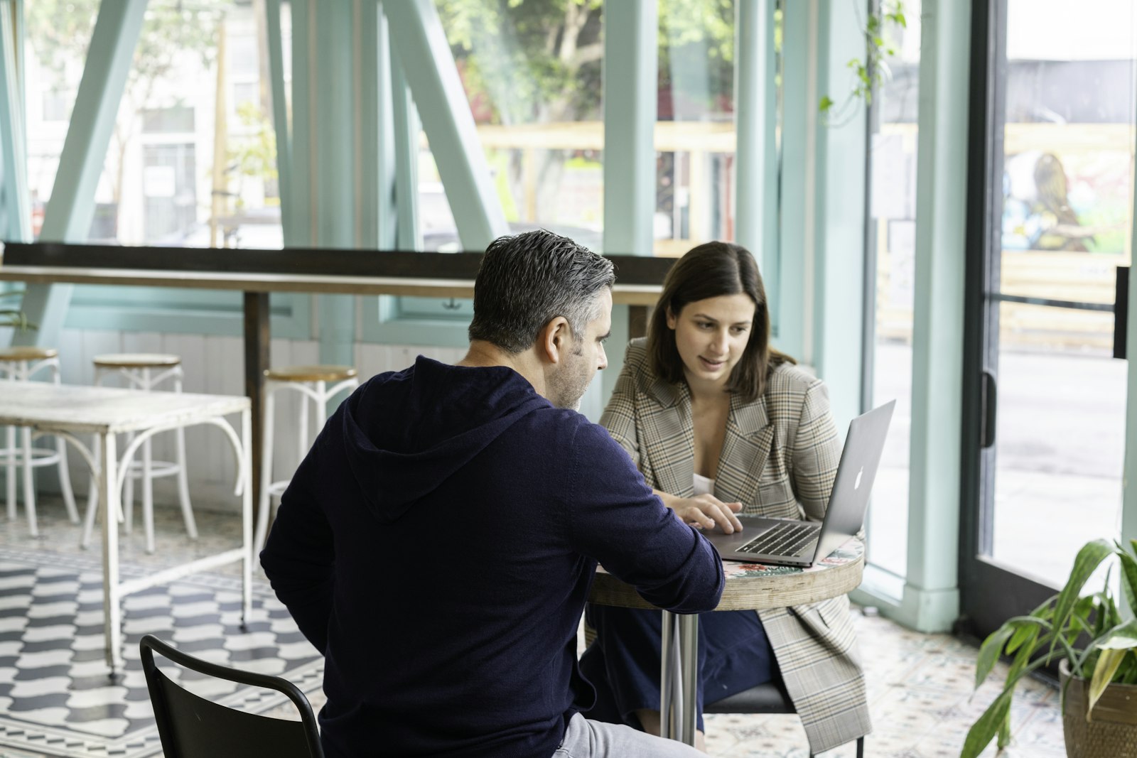 Een zelfstandige en een opdrachtgever bespreken documenten aan een vergadertafel